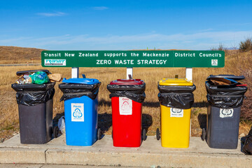 Row of multicolored garbage bins by the sidewalk for recycling