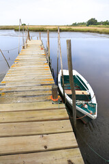 Obraz premium Boat docked in a port with wooden walkway