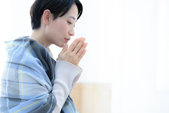 風邪や手先の冷え性で悩む美しい女性 青系（黄色系もあり）　アップ