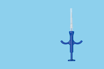pet chipping, syringe for animal microchip injection on blue background, copy space