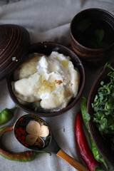boiled hot dumplings in a clay pot with fried onions and sour cream and hot peppers
