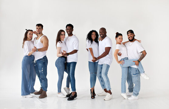 Group of young happy multiethnic couples isolated on white background looking at camera and smiling, wearing white T-shirts and jeans