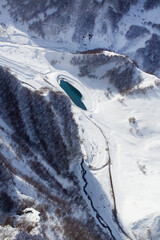 Winter landscape from a aerial view. Mountains, lake, snow. Vertical orientation. Top view