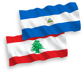 National vector fabric wave flags of Nicaragua and Lebanon isolated on white background. 1 to 2 proportion.