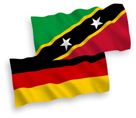 National vector fabric wave flags of Germany and Federation of Saint Christopher and Nevis isolated on white background. 1 to 2 proportion.