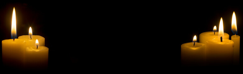 Lit candles in the corners of the picture in panoramic mode. Candles lit in the dark lighted candles on the sides of the picture for background. 