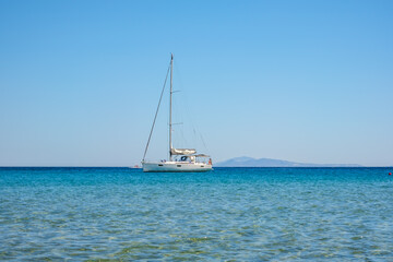 A sailboat at the famous  Mylopotas beach in Ios Greece