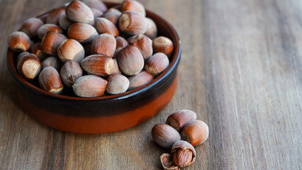 hazelnuts in a bowl on a wooden table