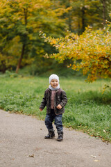 Mom and son walking and having fun together in the autumn park.