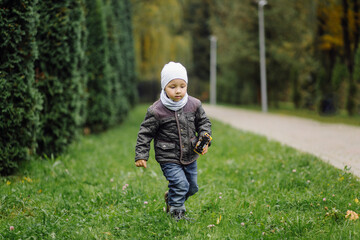 Fototapeta premium Mom and son walking and having fun together in the autumn park.