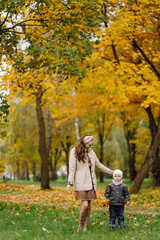 Mom and son walking and having fun together in the autumn park.