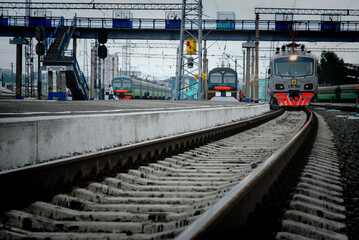 Fototapeta premium An electric train train arrives at the railway station of a small town in the summer