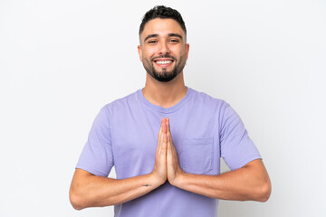 Young Arab handsome man isolated on white background keeps palm together. Person asks for something
