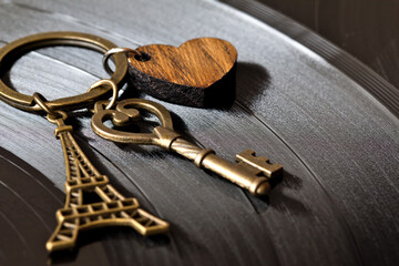 key with a keychain in the shape of a heart and an eiffel tower on a black background