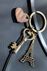key with a keychain in the shape of a heart and an eiffel tower on a black background