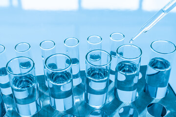 Chemistry experiment concept in science lab scientific chemistry glass vials of different sizes contain different chemicals. The chemicals are in many glass tubes lying on a table. blurred background