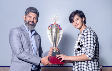 Indian man school teacher give victory golden trophy cup to girl student, Female receive winning...