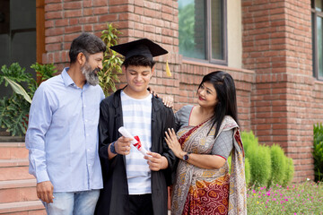 Indian university boy student and proud parents celebrating graduation degree convocation ceremony