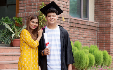 Indian university male student and proud mother celebrating graduation degree convocation ceremony
