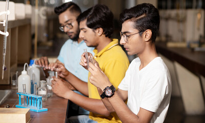 Group of indian students working or experimenting in science lab.