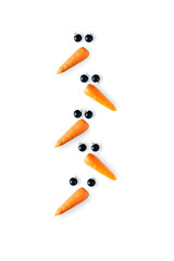 Creative snowman faces made of carrots and black Christmas balls in shape of christmas tree on a white background.