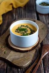 Traditional pumpkin cream soup with pumpkin seeds at wooden background