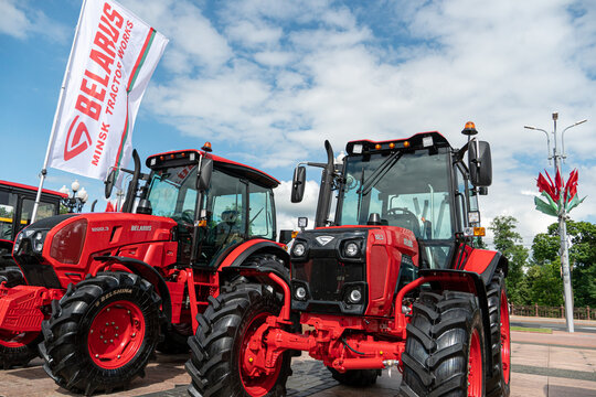 Belarus, Minsk, June 14, 2022: Open-air exhibition of modern wheeled agricultural machinery. New tractors stand in a row next to the flag on which the logo of the company Belarus is depicted