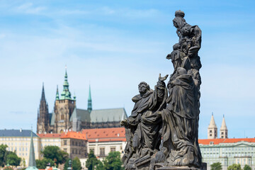 Fototapeta na wymiar Statue Of The Madonna, St. Dominic And Thomas Aquinas With Saint Vitus Cathedral On The Background, Prague, Czech Republic