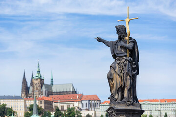 Statue Of Saint John The Baptist On Charles Bridge With Saint Vitus Cathedral On The Background, Prague, Czech Republic