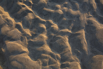 A close-up of the lines in the sand on the beach which are caused by wind and water.
