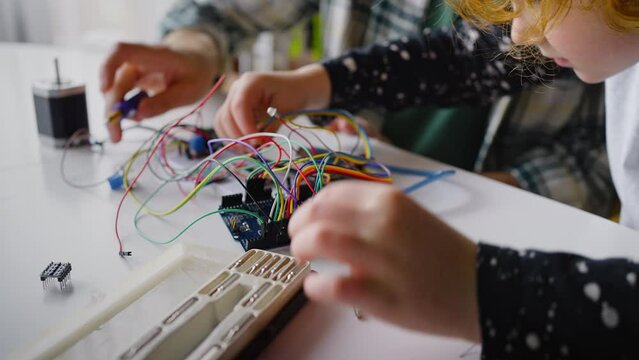 Experienced father teaches little son to work with electronics