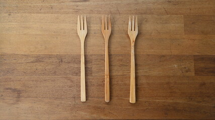 Three forks made of wooden high quality isolated on wooden table 