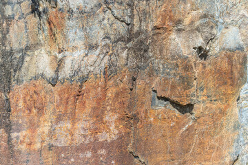 Rusted granite texture. Rusted stone background. Granite rocks. Colorful Old Cracked Rusty Rough texture. Rock wall backdrop with rough red brown texture. Grunge Abstract Stone Surface.