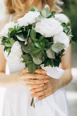 A happy young couple in love walk in a garden. A man in a white shirt and a girl in a white light dress are walking in a park