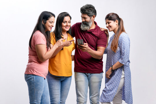Indian friend group watching smartphone on white background.