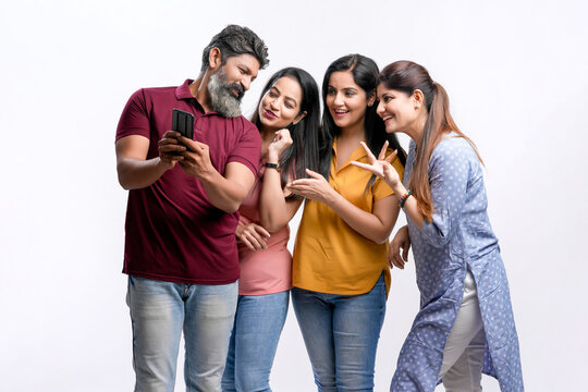 Indian friend group taking selfie on white background.