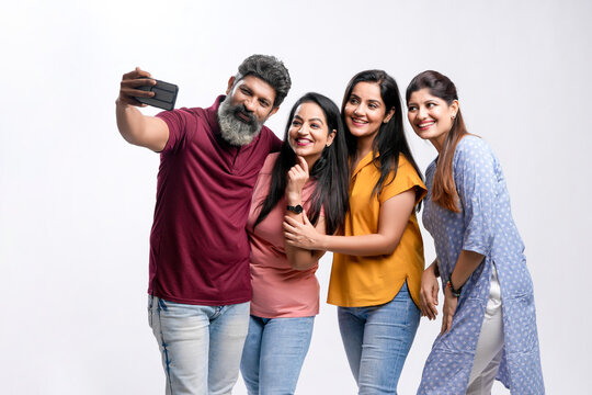 Indian friend group taking selfie on white background.