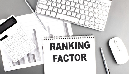 RANKING FACTOR text written on notebook on grey background with chart and keyboard, business concept