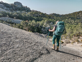 Woman hiking the long distance hike in Corsica called the GR20. A long hike with a heavy backpack. Hiking for two weeks with the most incredible views over the mountains. 