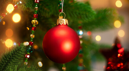 Fototapeta na wymiar Red ball of Christmas tree on background of garland. Christmas New Year