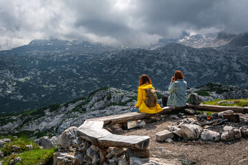 Two redhead girls are is looking at  the mountains, Hallstatt and surrounding mountains from 5 Fingers view point in Austria. Dachstein mountains.