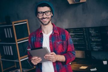 Photo of happy good mood coder dressed hat glasses creating presentation ereader modern gadget...