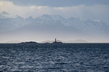 The Andres Mountains in the background with the silhouette of the Les Eclaireurs Lighthouse.  View from the back of the boat with the Ocean in the Foreground. 