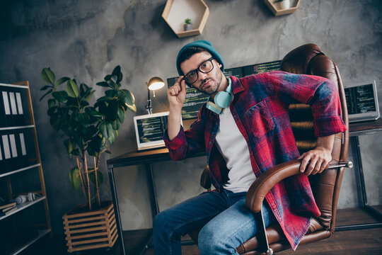 Photo of cool confident sound producer dressed hat glasses headphones creating writing music modern device indoors workplace workstation loft