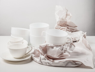 Paper-wrapped white ceramic utensils. Paper packaging for fragile items. Ecological packaging