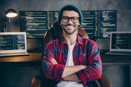 Photo of good mood happy coder dressed hat glasses smiling arms folded indoors workplace workstation loft