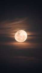 yellow full moon in night sky with clouds