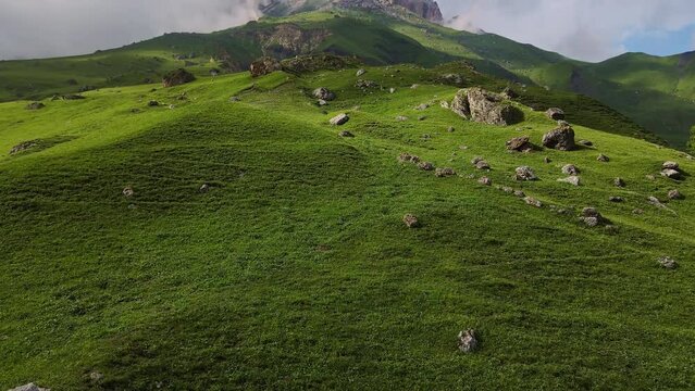 Aerial view of the mountainside and beautiful alpine green meadows