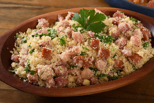 farofa with sausage, bacon and cabbage, typical Brazilian food, wood background