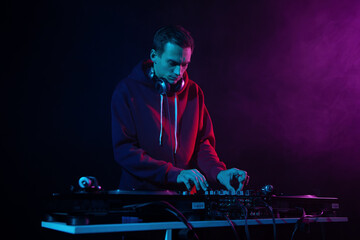 Hip hop party DJ plays vinyl music set with sound mixer and turntables. Club disc jockey mixing...